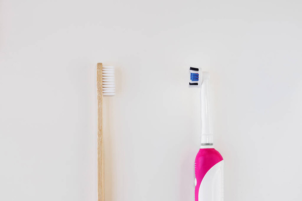 Cepillo de dientes de bambú vs concepto de cepillo de dientes de plástico. Residuos dentales cero y ningún concepto plástico. Espacio de copia, vista superior. Cepillo blanco orgánico natural. A salvo la tierra. Fondo blanco. Haga su elección
 - Foto, Imagen