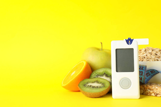 Blood glucose meter and diabetic food on yellow background - Photo, Image