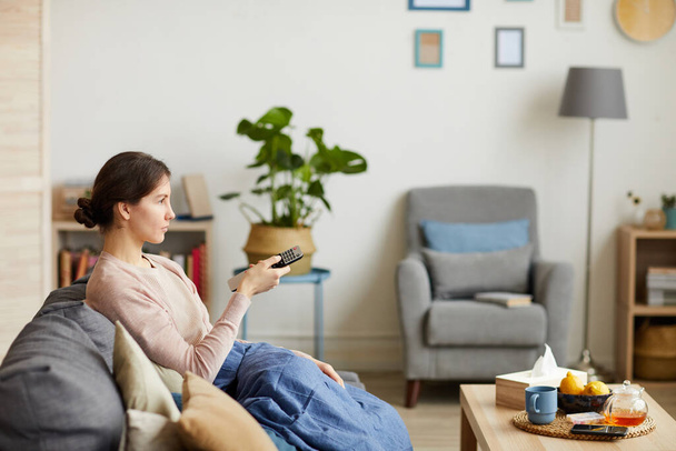 Woman watching TV at home - Фото, изображение