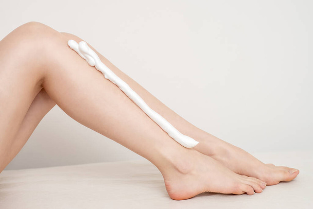 Shaving foam on female leg on white background isolation. - Photo, Image