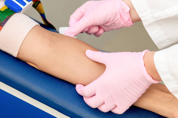 Handen van de verpleegkundige desinfecteer de armhuid voordat u het injectievaccin in een medisch centrum toedient. - Foto, afbeelding