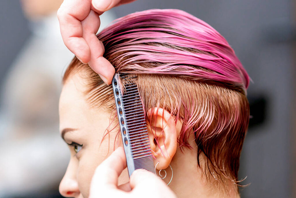 Fodrász fésülködés rózsaszín haj nő közelről a fodrászat. - Fotó, kép