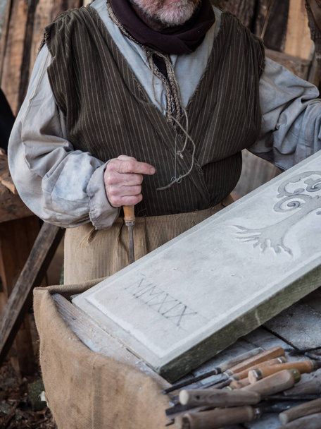 Stonemason carves and shapes the stone with a wooden hammer and chisel. - Foto, Bild