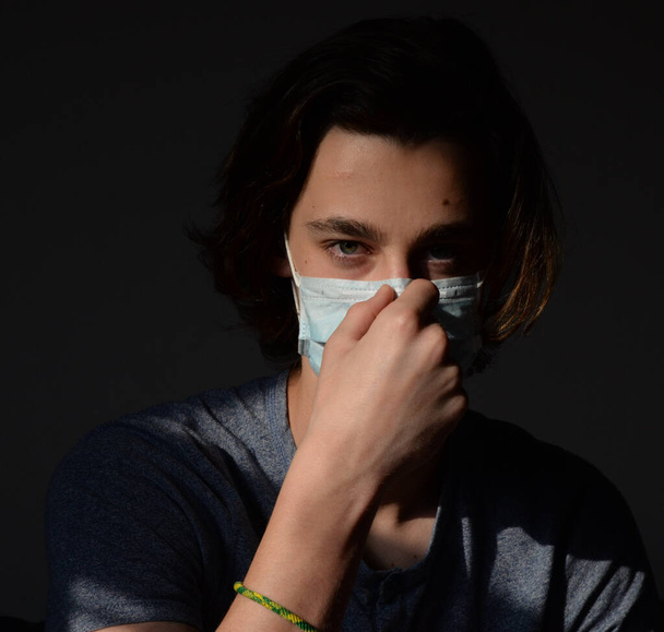 Medical mask worn on a young man - Foto, Bild
