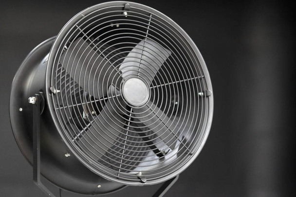 Geïsoleerd beeld van een ventilator die tegen een witte achtergrond werkt. Apparatuurventilator voor fotostudio - Foto, afbeelding