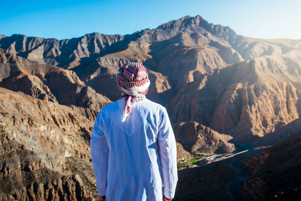 Homem árabe desfrutando da vista na montanha de arenito do deserto de Jebel Jais em Ras al Khaimah Emirados Árabes Unidos
 - Foto, Imagem