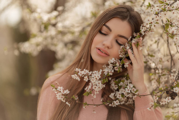 Beautiful natural woman during spring blossom time in cherry garden. - Fotografie, Obrázek