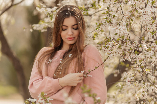 Beautiful natural woman during spring blossom time in cherry garden. - Foto, immagini
