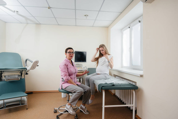 A pregnant girl is advised by a doctor after an ultrasound in the clinic. Medical examination - Photo, Image