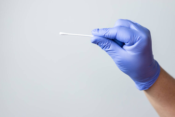 blue gloved hand holding coronavirus nasal test stick, or covid-19. Coronavirus test concept. - Photo, image