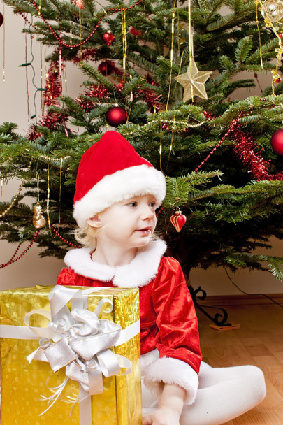 klein meisje als santa claus met kerstcadeau - Foto, afbeelding