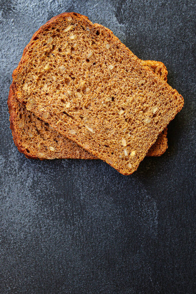 чорний житній хліб з корисними добавками та насінням (пекарськими скибочками) концептуальний фон меню. вид зверху. копіювання простору для тексту
 - Фото, зображення