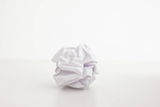 Crumpled up white piece of paper close up shot isolated on bright background 2020 - Foto, afbeelding