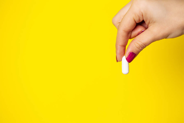 Γυναίκα κρατά λευκό χάπι στο χέρι της για την απώλεια βάρους - Φωτογραφία, εικόνα
