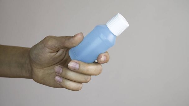 Vrouw hand met een plastic fles alcohol gel.  - Foto, afbeelding
