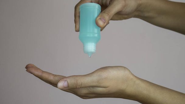 Bottle with antibacterial antiseptic gel in woman's hand.  - Photo, Image