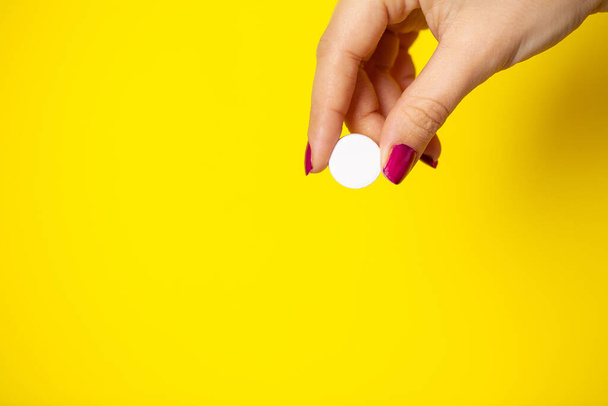 Žena drží bílou pilulku v ruce na hubnutí - Fotografie, Obrázek