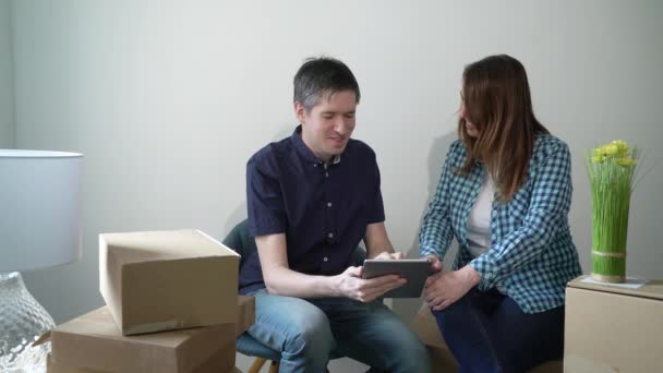 Young couple moving in new home. Sitting on floor and relaxing - Séquence, vidéo