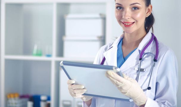 Woman doctor standing with folder at hospital - Photo, Image
