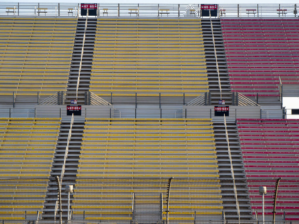Suuri stadionin istuimet kilparadalla iltapäivällä istuu tyhjä
. - Valokuva, kuva