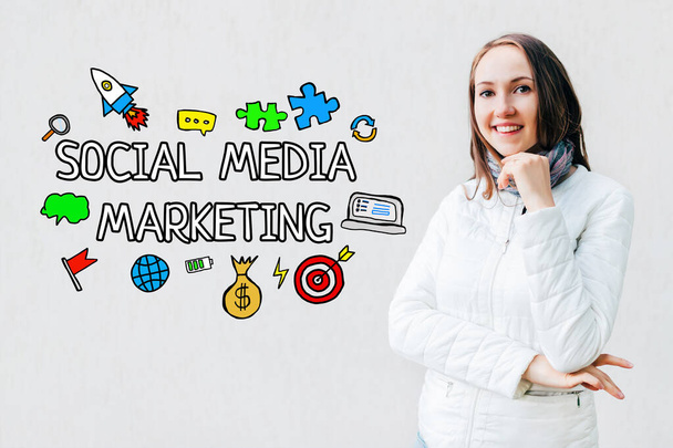 Concepto de marketing en redes sociales - chica en un fondo blanco con texto e iconos. De cerca.
. - Foto, Imagen