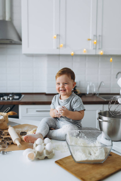 happy family funny boy preparing the dough, bake cookies in the kitchen - Φωτογραφία, εικόνα