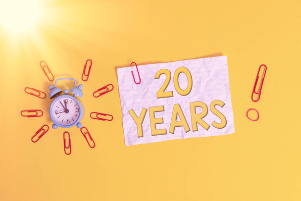 Szövegírás 20 év. Üzleti koncepció emlékére vagy tiszteletére különleges nap, hogy 20 éve létezik Fém vintage riasztó kapcsok zúzott lap gumiszalag színes háttér. - Fotó, kép