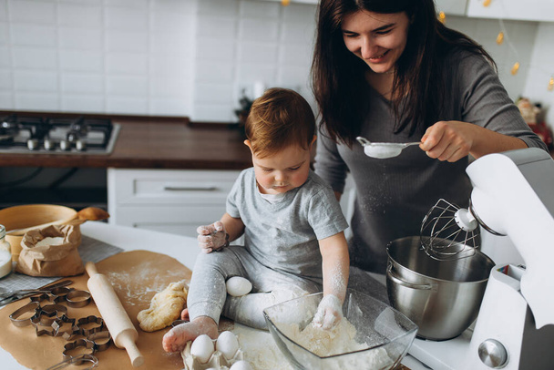 happy family in the kitchen. mother and son preparing the dough, bake cookies - Фото, зображення