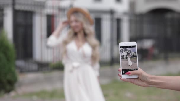 Βραχίονας με smartphone λήψη φωτογραφιών μιας γυναίκας με φόρεμα. - Πλάνα, βίντεο