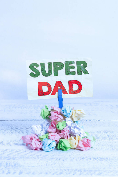Word writing text Super Dad. Business concept for Children idol and super hero an inspiration to look upon to Reminder pile colored crumpled paper clothespin reminder white wooden space. - Photo, Image