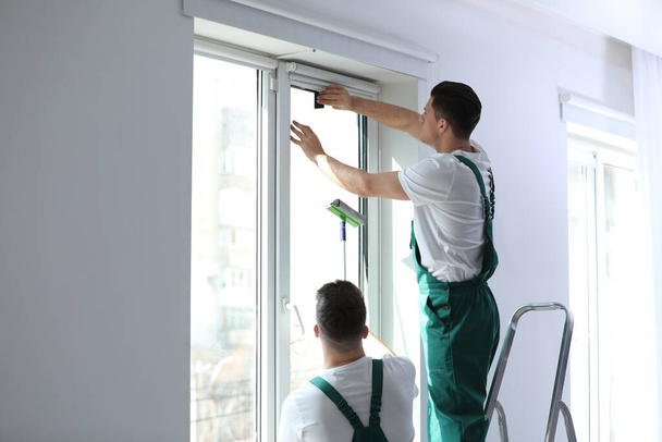Professional workers tinting window with foil indoors - Zdjęcie, obraz