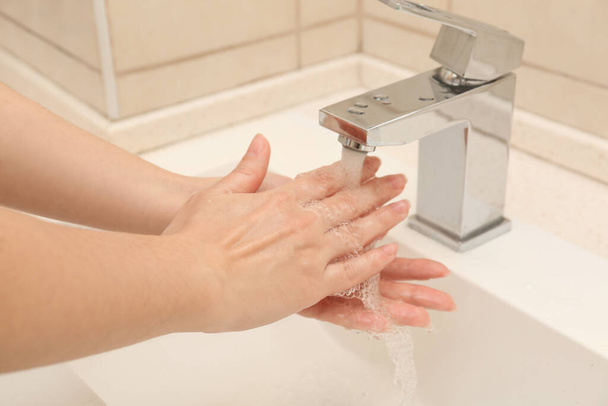 Woman washing hands with antiseptic soap in bathroom, closeup - Foto, Imagen