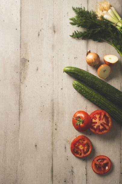 Čerstvé okurky, rajčata cibule a kopr na světle barevné dřevěné pozadí - Fotografie, Obrázek