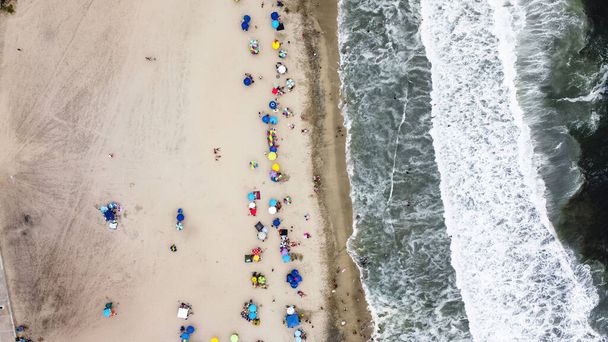Krásný letecký výhled s dronem na jednu z pláží jižně od Limy v Peru, kde můžete vidět deštníky a lidi užívající si léta. - Fotografie, Obrázek