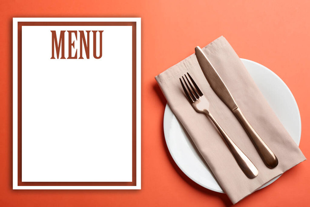 Elegant table setting and empty menu on orange background, flat lay. Space for text - Фото, зображення