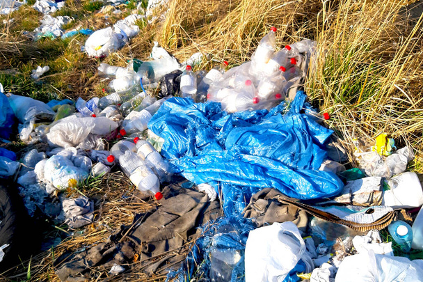 Składowanie odpadów z tworzyw sztucznych wyrzucanych na pole nie jest dozwolone w przypadku śmieci. - Zdjęcie, obraz