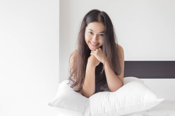 Giovane bellezza felice donna asiatica seduta sul letto con faccina sorridente
. - Foto, immagini