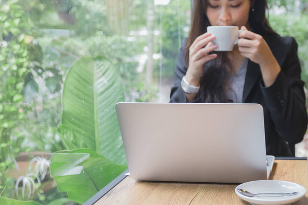 Молода красуня азіатська бізнес-леді з ноутбуком смартфон і кавою на столі в робочому просторі..  - Фото, зображення