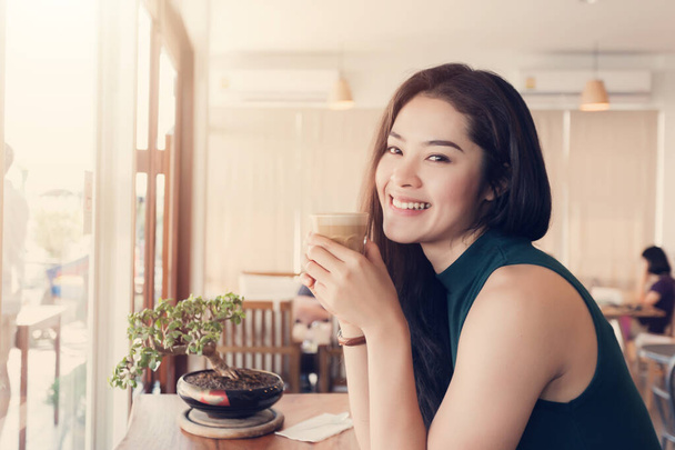 Jeune femme asiatique heureuse buvant du café dans le café
. - Photo, image