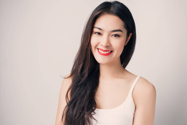 Fiatal gyönyörű ázsiai nő mosolygós arccal és vörös ajkakkal. - Fotó, kép