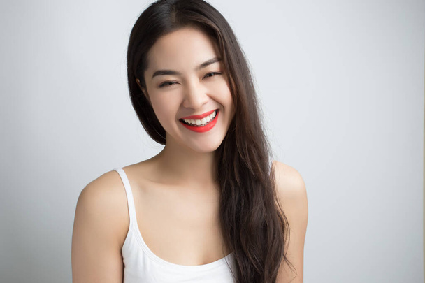 Fiatal gyönyörű ázsiai nő mosolygós arccal és vörös ajkakkal. - Fotó, kép