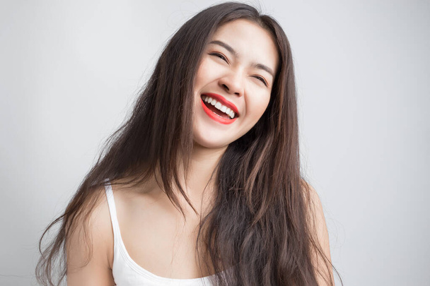 Молодая красивая азиатка с улыбкой на лице и красными губами. - Фото, изображение