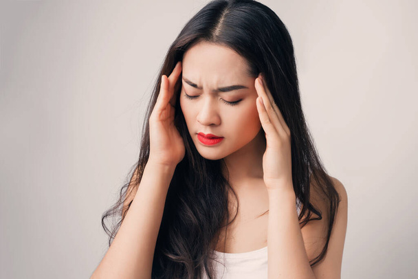Jovem mulher asiática tem dor de cabeça esticada seriamente
.  - Foto, Imagem