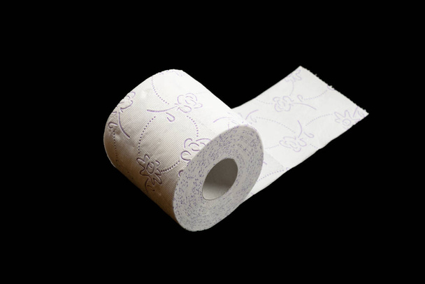 Toiletpapier roll geïsoleerd op zwart. Zacht weefsel achtergrond. Badkamer hygiëne concept - Foto, afbeelding
