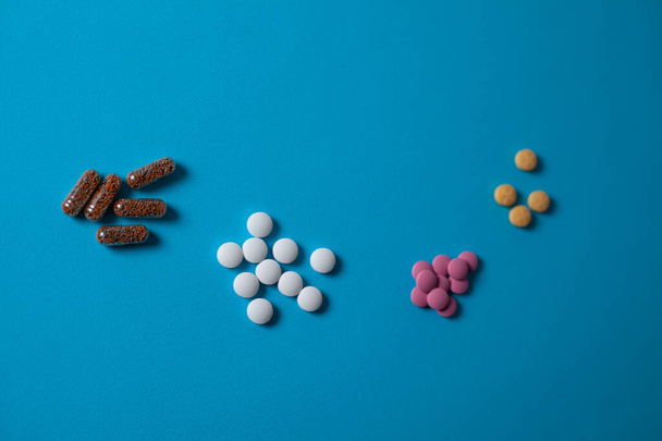 pastillas médicas sobre un fondo azul. flatlay
 - Foto, imagen