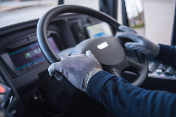 bus driver with mask puts protecting gloves on his hand in bus to protect himself from the coronavirus epidemic. covid 19. protect from corona virus. quarantine 2020. stay home. - Fotografie, Obrázek