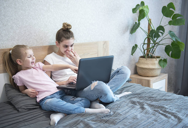 Koulutytöt opiskelevat kotona kannettavan tietokoneen avulla. Pysy kotona. Online koulutus, kotiopetus, karanteeni käsite
 - Valokuva, kuva