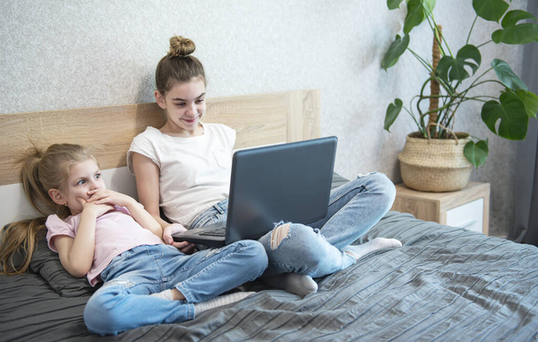 Iskoláslányok otthon tanulnak laptoppal. Maradj otthon. Online oktatás, otthoni oktatás, karantén koncepció - Fotó, kép