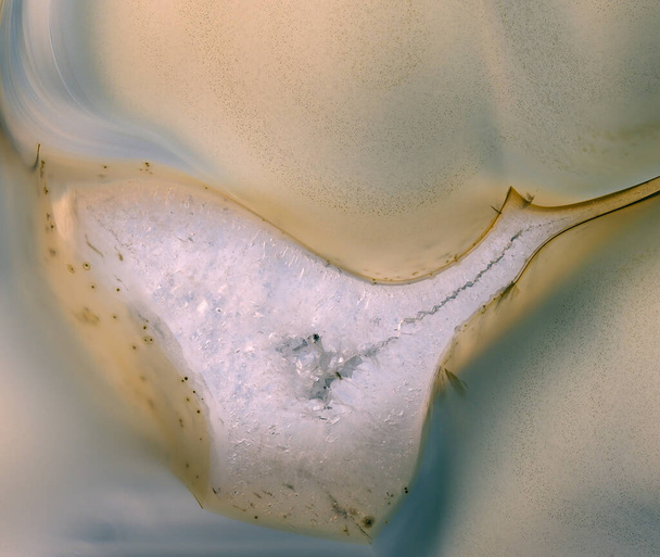 Μακρό κλείσιμο ενός μικροσκοπικού τμήματος ενός κομματιού χαλαζία σε μια φέτα αχάτης πέτρας - Φωτογραφία, εικόνα