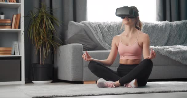 Beautiful woman in virtual glasses doing yoga exercise - Filmati, video